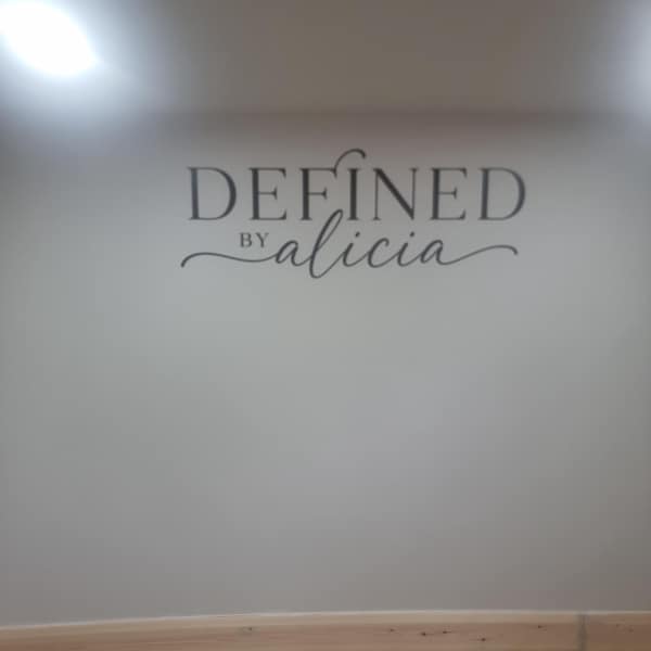 Defined by Alicia lettering applied to a pale salon wall.