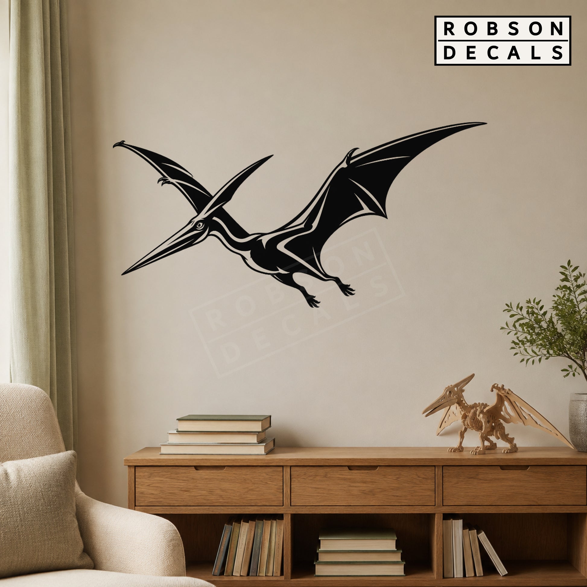Black flying pterodactyl wall decal above an oak console in a reading nook, styled Robson Decals mockup
