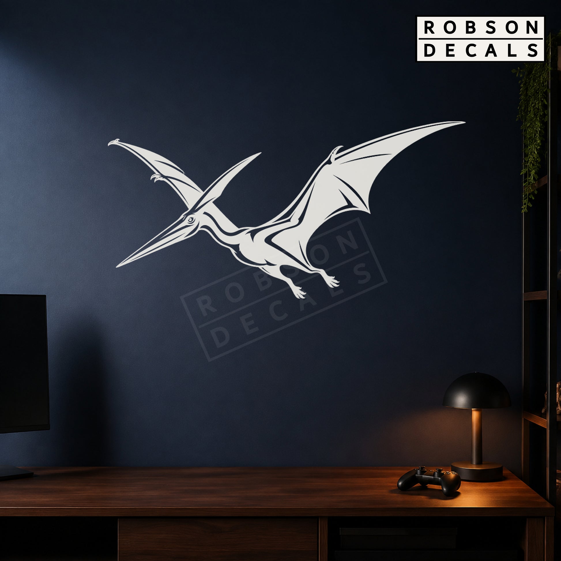 White flying pterodactyl wall decal on a navy games room wall, styled Robson Decals mockup