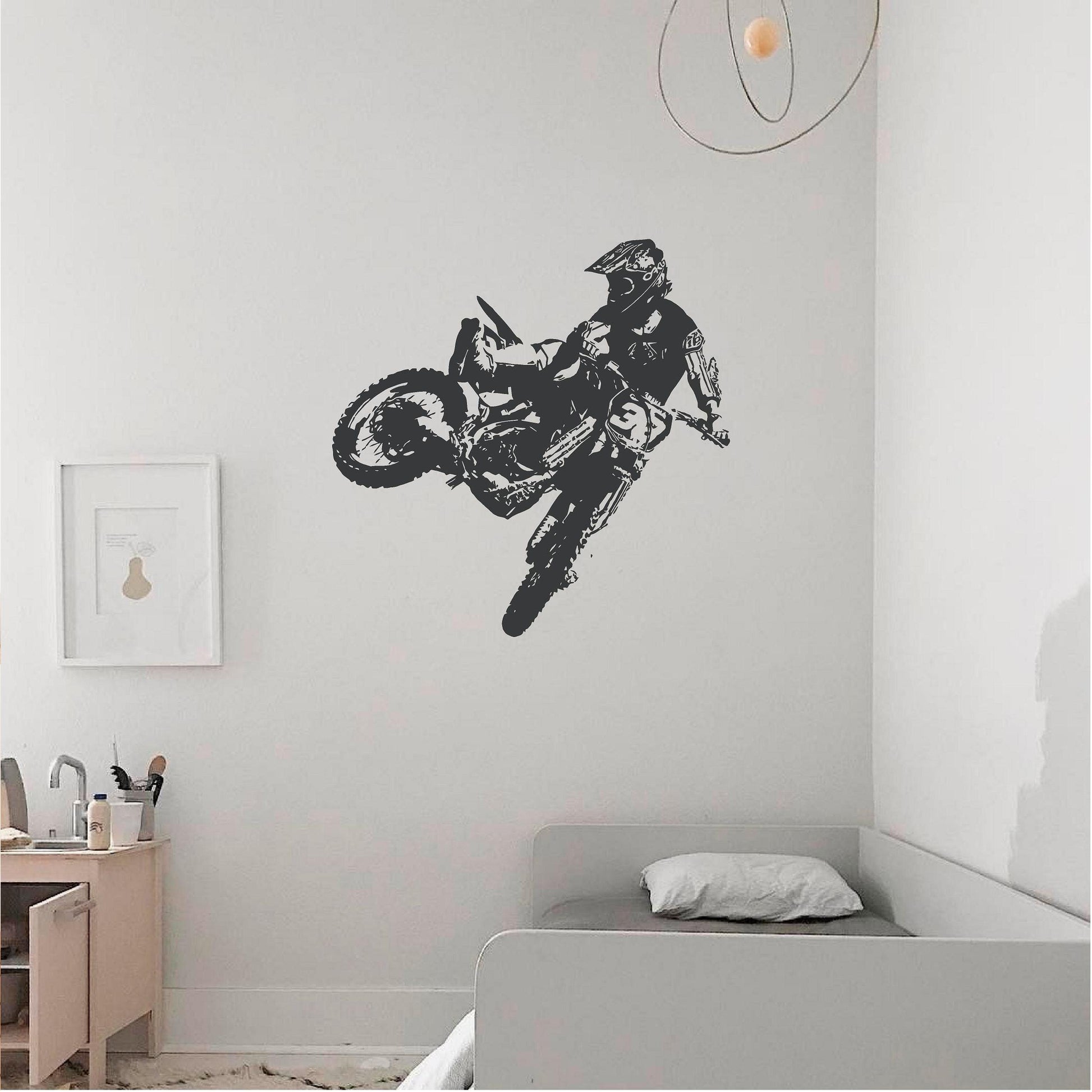 Dark grey motocross rider wall decal above a daybed