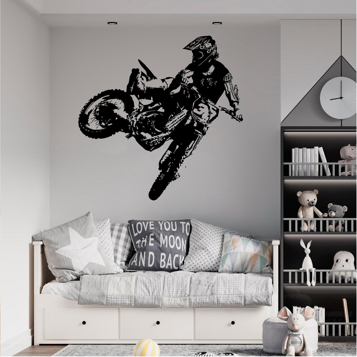 Black motocross rider wall decal above a grey daybed