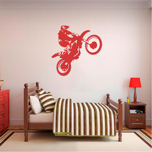 Red motorbike wheelie rider wall decal above a wooden single bed.