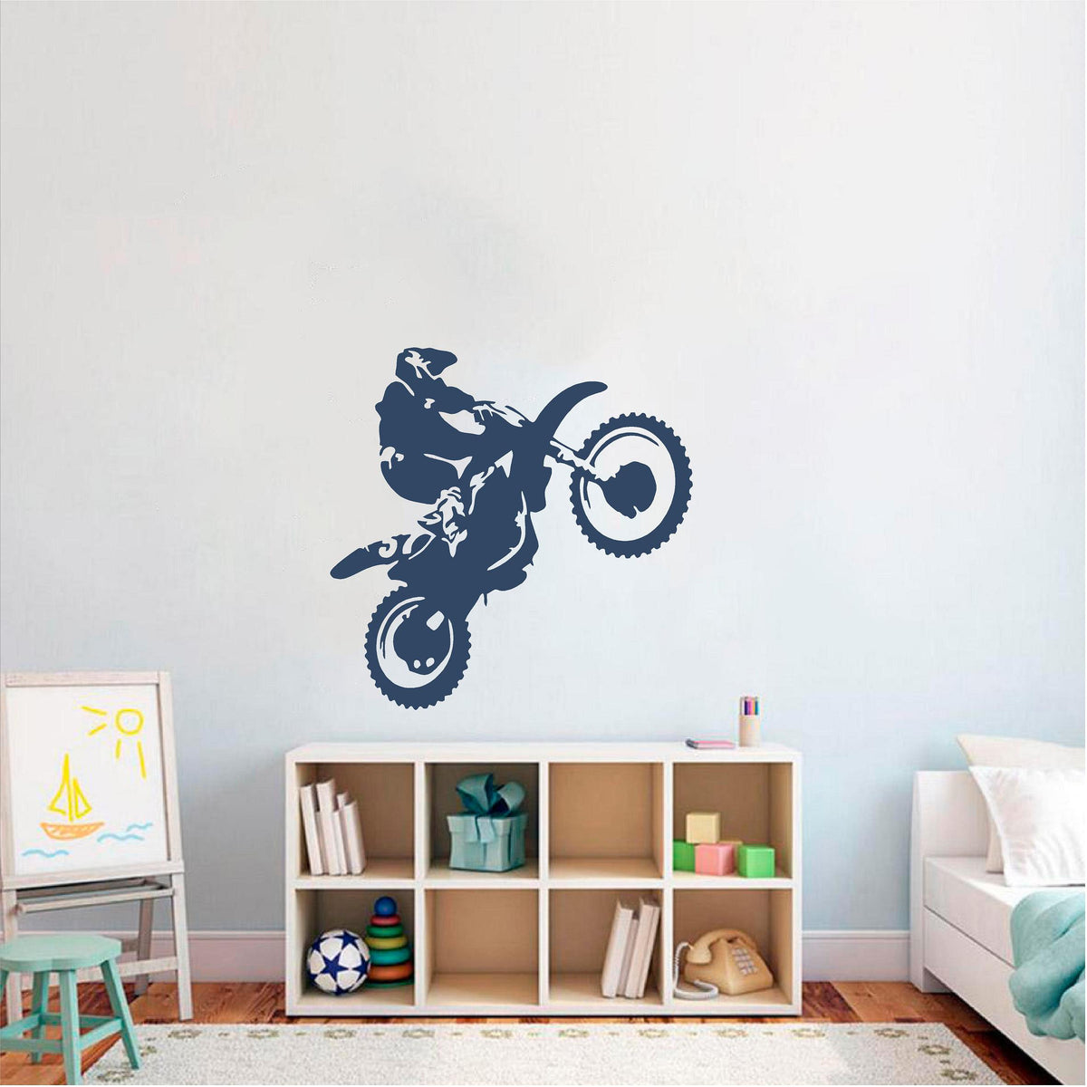 Navy blue motorbike wheelie rider wall decal above a cube shelf in a child's room.