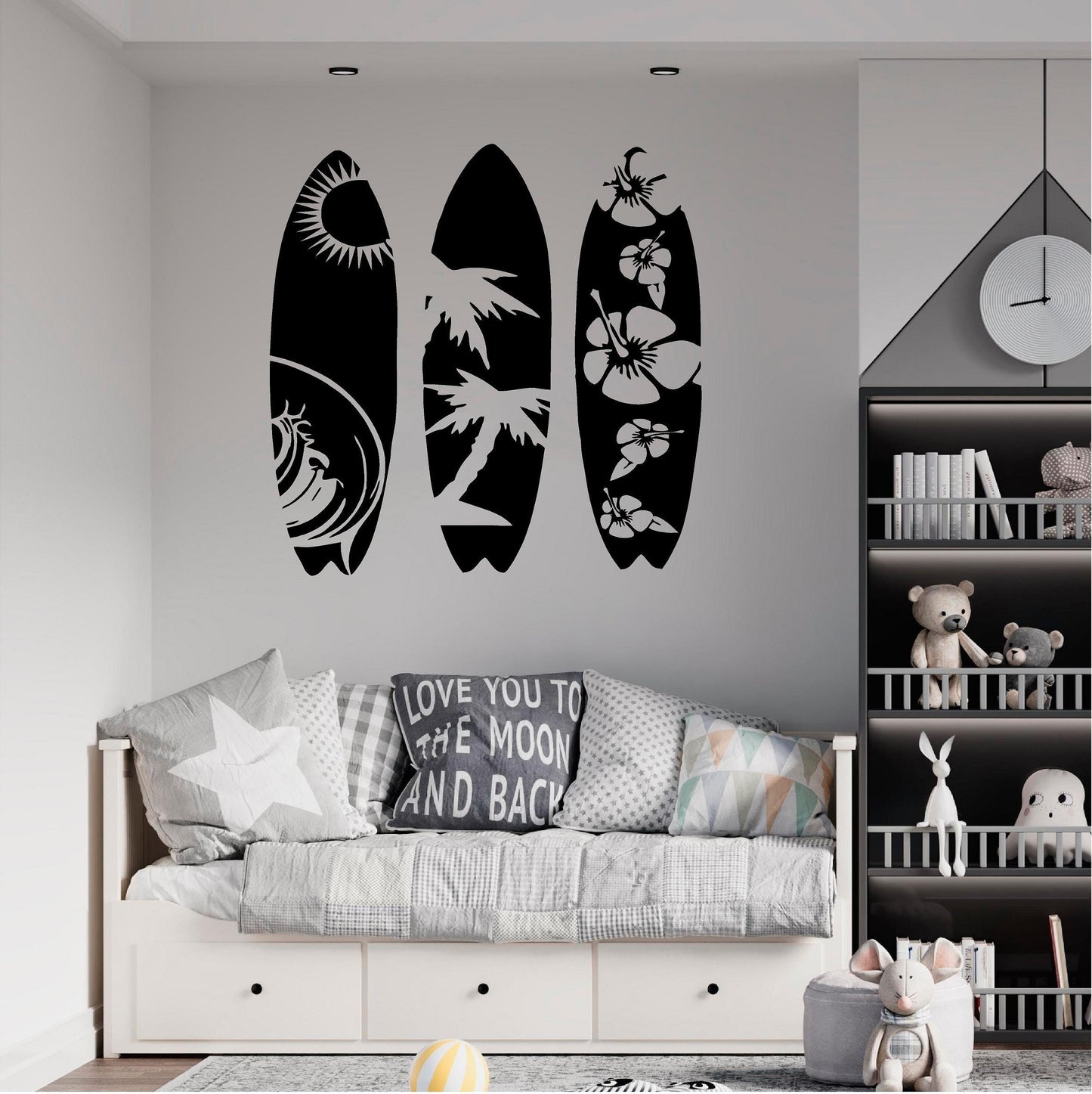 Black tropical surfboard wall decal set above a grey daybed