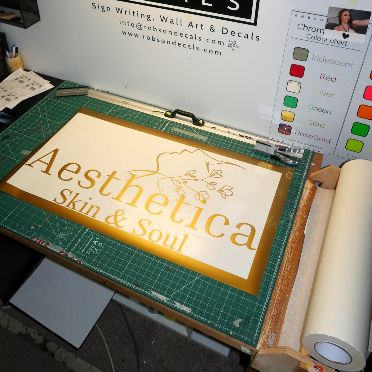 Aesthetica — Gold lettering with a delicate face and floral illustration.
