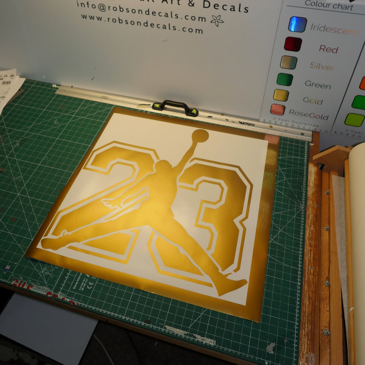 Basketball silhouette — A gold basketball silhouette over large outlined numerals.